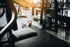 Empty fitness gym with equipment interior at morning with sunrise. Modern and Healthy concept.